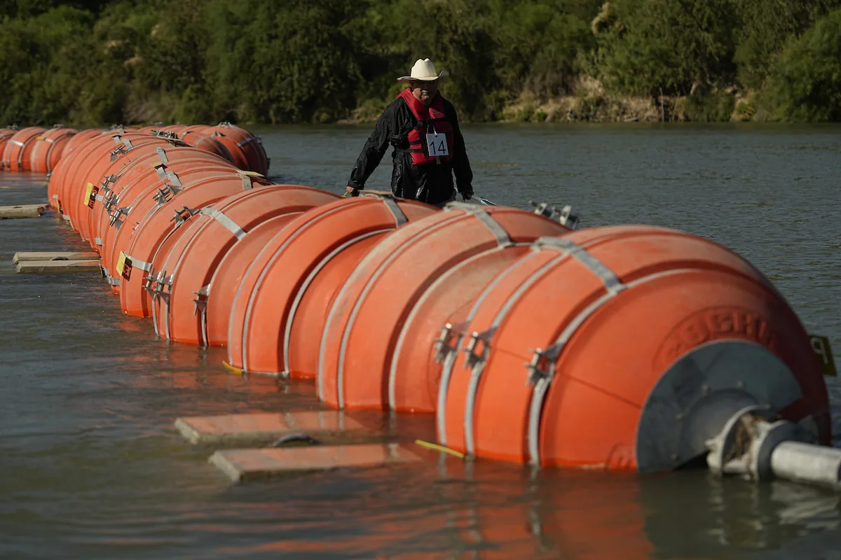 Operarios retirando la barrera flotante del río Bravo tras la orden judicial en la frontera entre Texas y México.