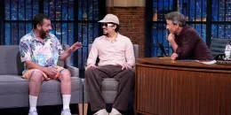 Bad Bunny y Adam Sandler sentados en el estudio de Late Night con Seth Meyers