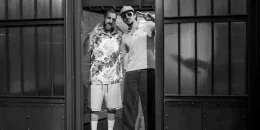 Bad Bunny y Adam Sandler sentados juntos en el set de Late Night con Seth Meyers