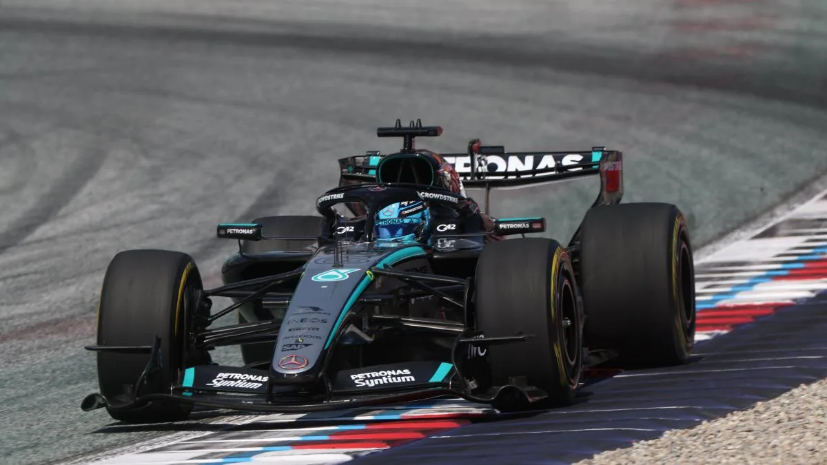 Coches de Fórmula 1 compitiendo en pista con Verstappen y Russell visibles