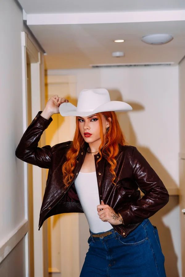 Reddy, artista trans brasileña, actuando en escenario con estética sertaneja moderna