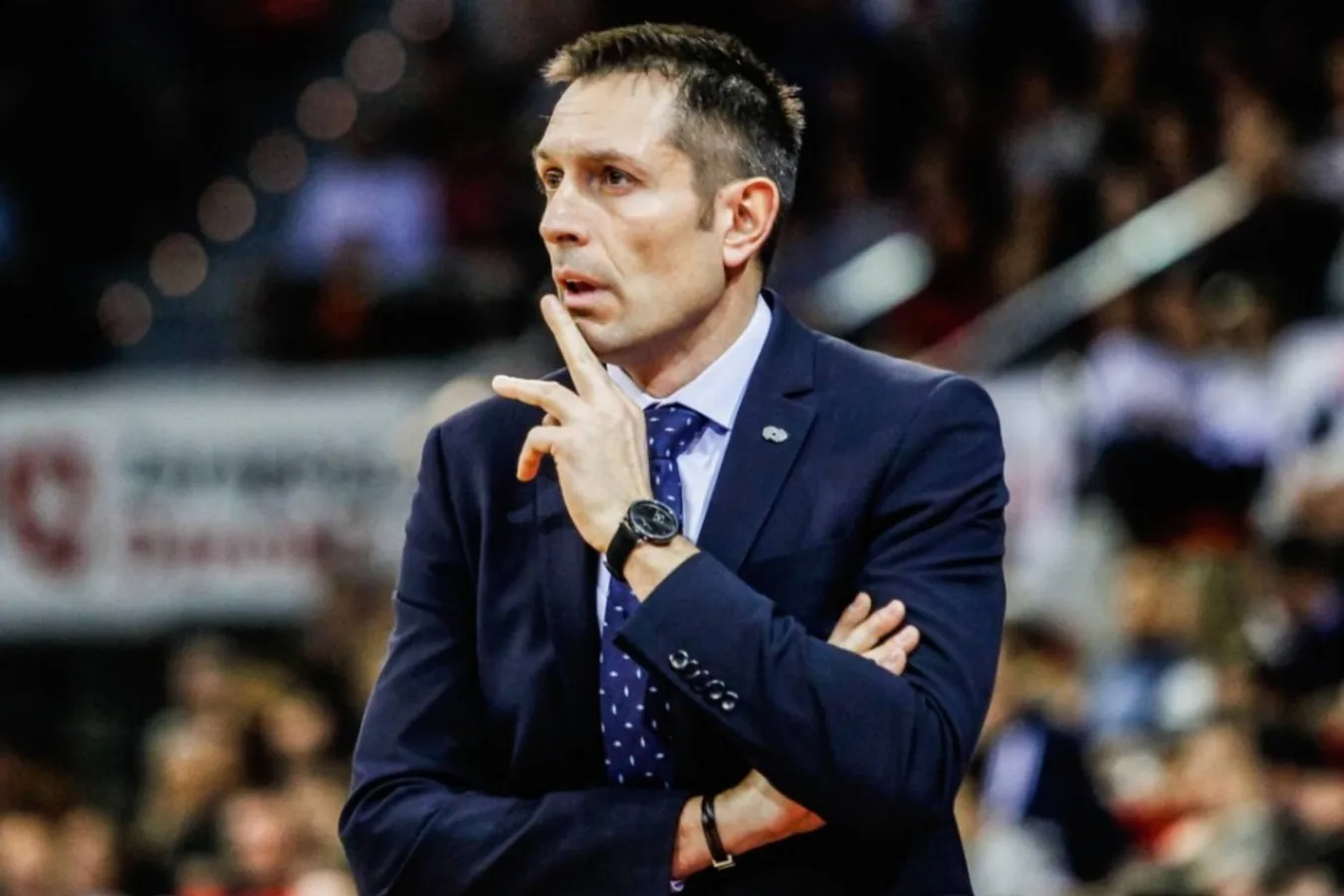 Entrenador del Movistar Estudiantes gritando instrucciones a sus jugadores en una cancha de baloncesto.