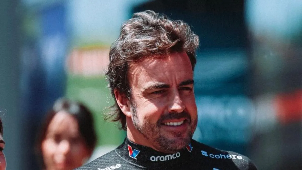 Fernando Alonso sonriente junto a su monoplaza de Fórmula 1 tras la sesión de clasificación.